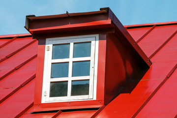 Red Seam Roof. Window on the Attic Floor. Exterior