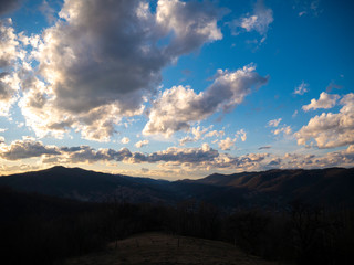 Naklejka na ściany i meble Beautiful landscape in the mountains at sunset. View of colorful sky with amazing clouds.