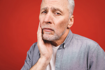 Close-up portrait of senior aged man suffering from toothache o