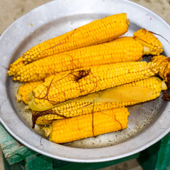 Boiled corn on an aluminum tray. Yellow boiled young corn, useful and tasty food