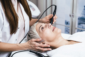 Beautiful senior woman having mesotherapy at cosmetic beauty salon.