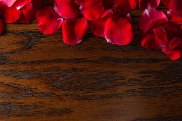 Naklejka na ściany i meble Red Rose Petals on Dark Wooden Background. Valentines Day Romantic Concept.