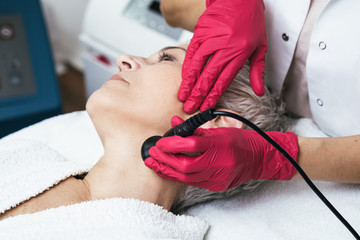 Beautiful senior woman having mesotherapy at cosmetic beauty salon.
