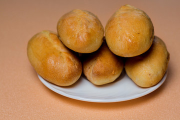 Pies with meat, cabbage or any filling. Baked pies in the oven. On a white plate.