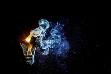 Сosmic explosion of burning light bulb with flying splinters of broken glass and smoke on isolate...