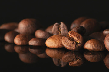 Coffee Beans close up isolated on black background. Space for copy text. Close up food. Arabica beans for making delicious and aromatic hot caffeine drink.