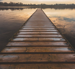 A dangerous frozen wooden walkway leads out into the middle of a lake