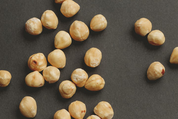 hazelnut nuts scattered on black paper background