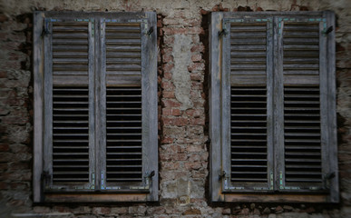An old wooden window on an old brick house.