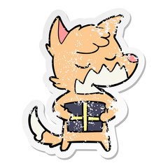 distressed sticker of a friendly cartoon fox with christmas present
