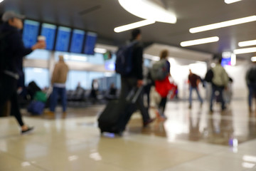 Fototapeta premium Nieostre niewyraźne bokeh podróżnych w terminalu lotniska podróżujących do pracy i wakacji - streszczenie tło