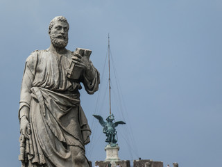 Fototapeta na wymiar Statue of the apostle St. Peter holding a book, with the pedestal inscription Rione XIV, on Ponte Sant'Angelo, Rome, Italy. The sculpture was by the Italian Renaissance sculptor Lorenzetto