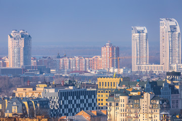 Naklejka premium Early spring at sunny evening in warm weather. Industrial zone and residential areas Podin and northern suburbs Obolon in Kyiv on the right bank of the Dnipro River. Ukraine Mar. 6, 2019