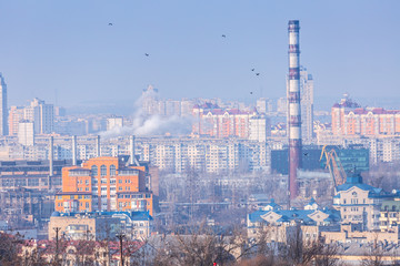Early spring at sunny evening in warm weather. Industrial zone and residential areas Podin and northern suburbs Obolon in Kyiv on the right bank of the Dnipro River. Ukraine Mar. 6, 2019