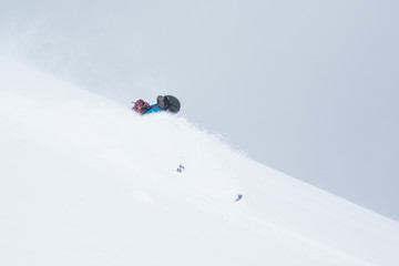 Naklejka na ściany i meble Backcountry skier in blue with backpack turning through deep powder snow of Hokkaido Japan.