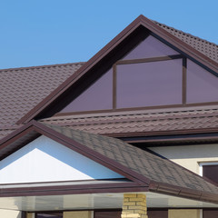House with plastic windows and a brown roof of corrugated sheet