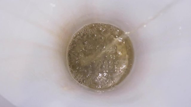 Man pissing in toilet and flushing close-up