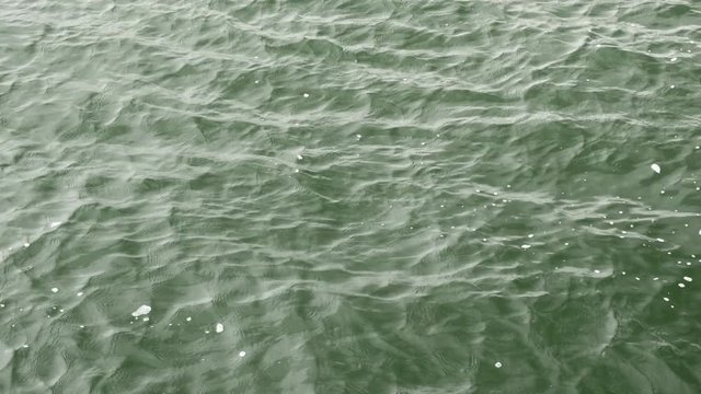 Close shot lake, see or ocean green water wavy surface.