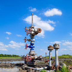 Oil well after repair in mud and puddles.