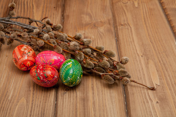 Still life with Pysanka, decorated Easter eggs, dry willow branches on black wooden background, top view, copy space