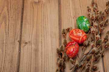 Still life with Pysanka, decorated Easter eggs, dry willow branches on black wooden background, top view, copy space