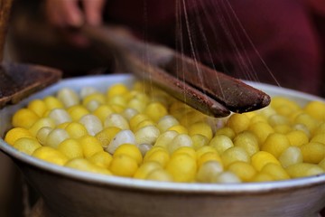 Mutating boiled silkworm cocoons on hot water A yarn to silk weaving.To be used as a garment.