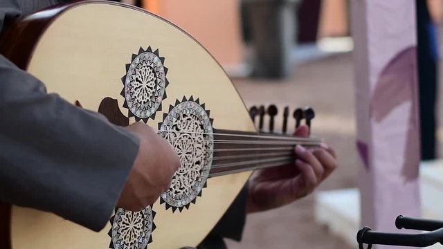 Arabic man from Saudi Arabia plays music on traditional Arabic instrument called Audh