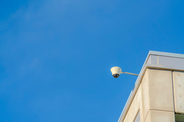 Dome security camera on a building against sky