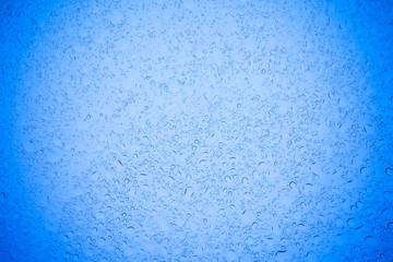 Rain droplets on blue glass background, Water drops on blue glass.