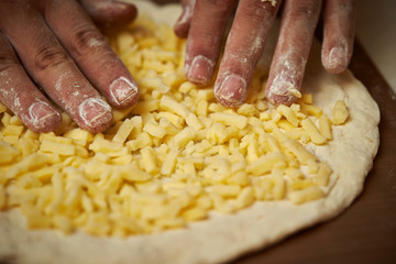 Putting cheese on pizza dough