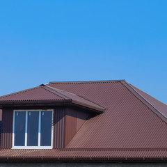 House with plastic windows and a brown roof of corrugated sheet
