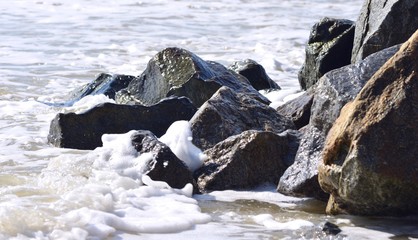 sea stones on the sea can be seen as a wave washes them in the summer