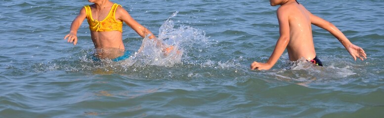 Guys pose for a photographer on the sea in the summer of kupayasb in the water in motion