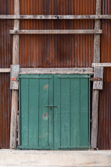 Antique green wooden door with old zinc wall vintage style