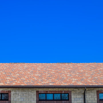 The house is made of beige bricks, the roof is covered with bitumen shingles. Metal plastic windows on the house.