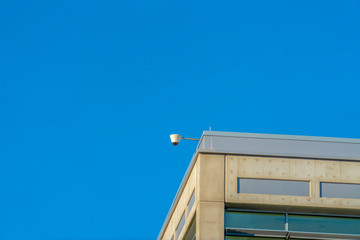 Security camera on tp of a building on a sunny day