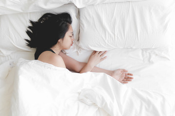 Woman has a deep sleep on white bed. Concept of tried and rest.