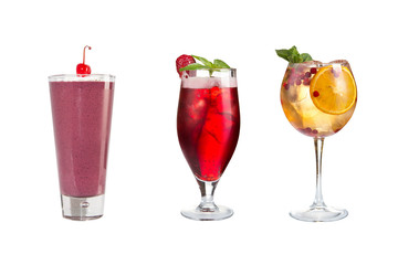 A variety of alcoholic drinks, beverages and cocktails on a white background. Three drinks in glass goblets decorated with berries.