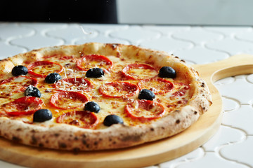 Grating cheese on pepperoni pizza 