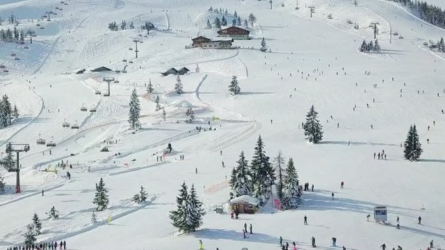 4k Drone Aerial of people doing Winter sport in the Alps, Flachau, Austria. FULL ZOOM