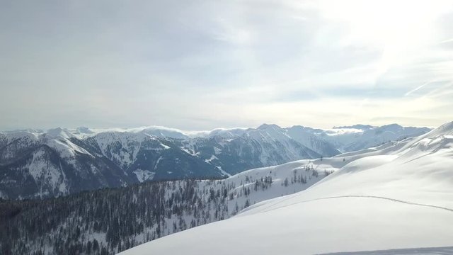 Solo person on a snowy mountain, snowboarding, with amazing views of the French Alps. Flachau, Austria