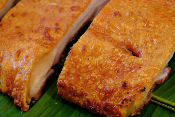 Deep grilled crispy pork belly on fresh banana leaf