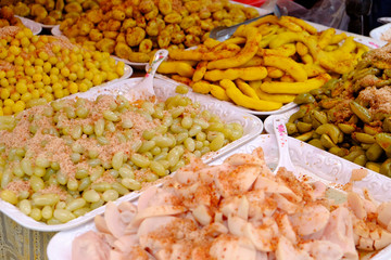 Multiple types of pickled young fruits with the taste of sweet sour and spicy, such as grapes, tansol, tamarind, star gooseberry in white dishes