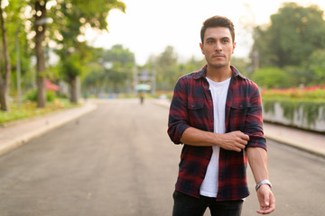 Young thoughtful Hispanic hipster man at the park