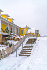 Snowy stairs along wooden fence of homes in Utah