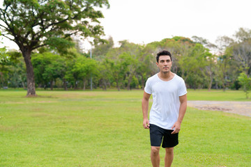 Young handsome Hispanic man jogging in the park outdoors