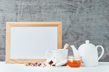 Kitchen utensils background with empty white paper, teapot, cup and a honey in glass jar, kitchen mock up with copy space