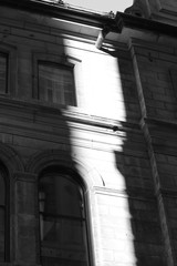Black and white picture. Sunlight on a building.