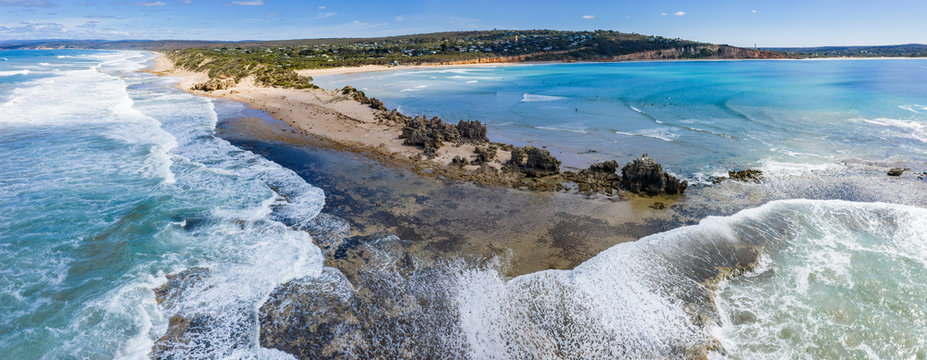Aerial panoramic view of the Point Roadknight limestone rock outcrop with the beach, coastline and houses in Anglesea Victoria, Australia