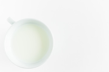 milk in a round white mug on a white background